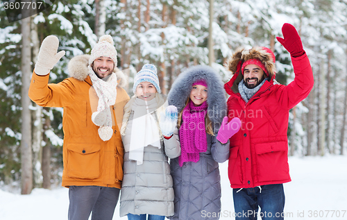 Image of group of friends waving hands in winter forest