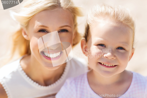 Image of happy mother and little daughter on summer beach