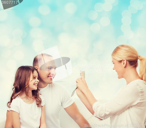 Image of happy family with camera at home