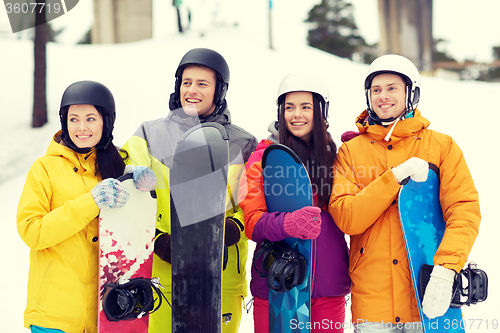 Image of happy friends in helmets with snowboards