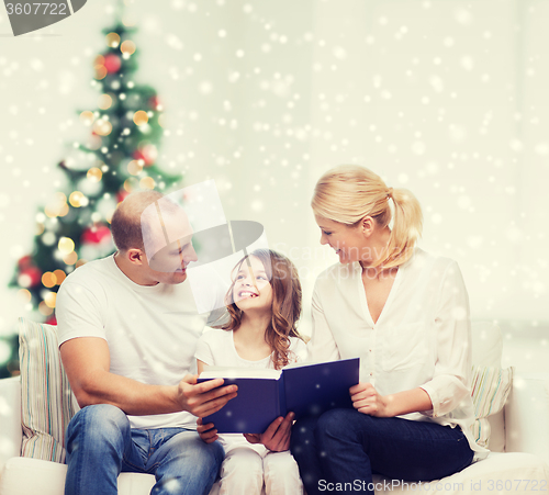 Image of happy family with book at home