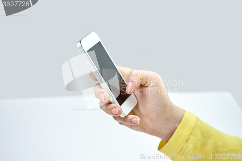 Image of close up of female hand with smartphone at home