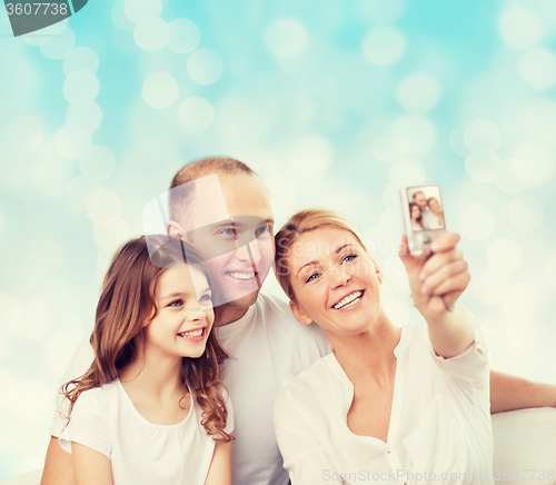 Image of happy family with camera at home