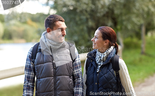 Image of happy family walking with backpacks in woods