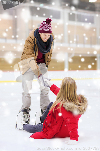 Image of man helping women to rise up on skating rink