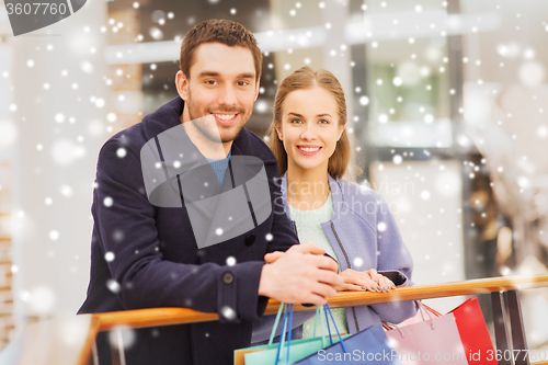 Image of happy young couple with shopping bags in mall