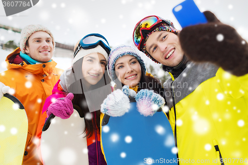 Image of happy friends with snowboards and smartphone