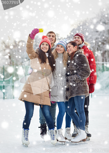 Image of happy friends with smartphone on ice skating rink