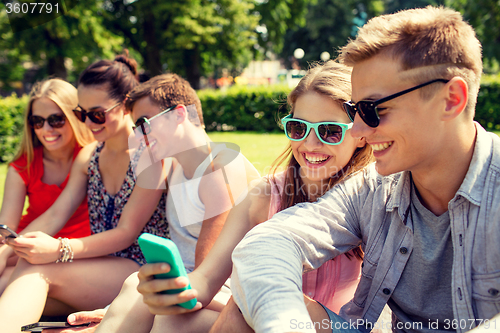 Image of smiling friends with smartphone making selfie