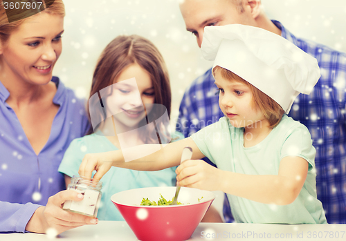 Image of happy family with two kids making salad at home