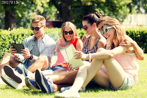 Image of smiling friends with tablet pc computers in park