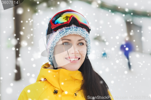 Image of happy young woman in ski goggles outdoors