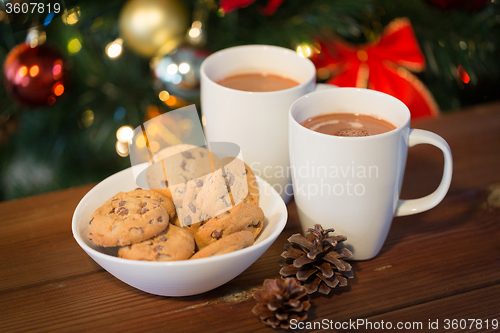 Image of oat cookies and hot chocolate over christmas tree