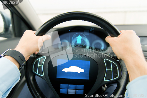 Image of close up of man driving car with icon on computer