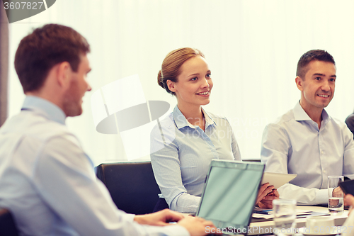 Image of smiling business people with tablet pc in office