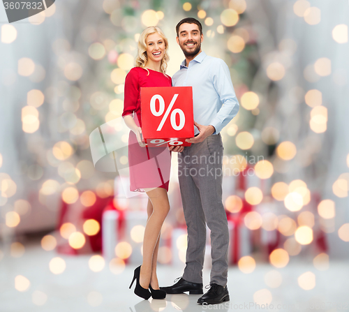 Image of happy couple with sale sign over christmas lights