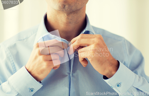 Image of close up of man in shirt dressing 