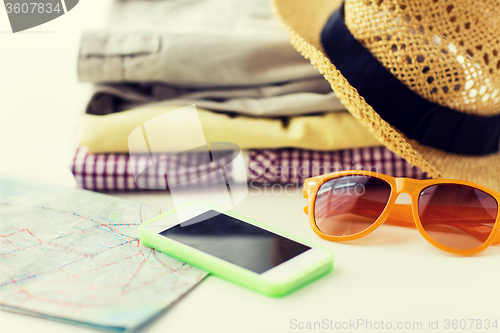 Image of close up of summer clothes and travel map on table