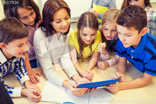 Image of group of kids with teacher and tablet pc at school