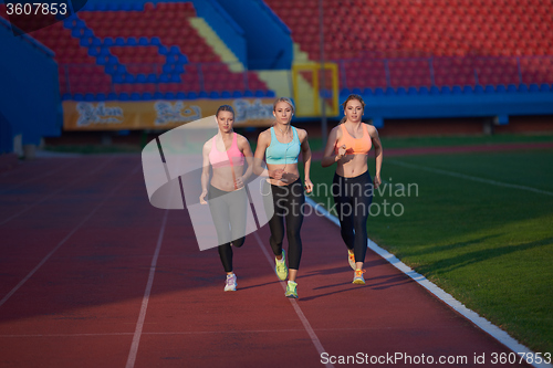 Image of athlete woman group  running on athletics race track