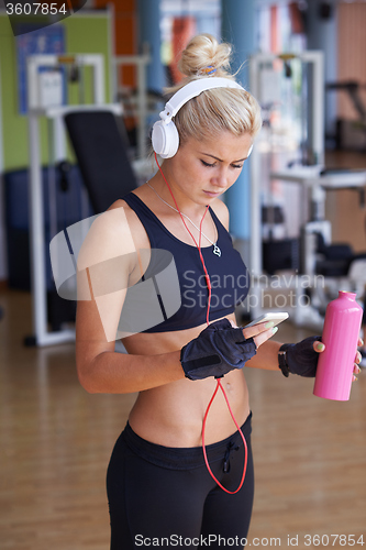 Image of woman with headphones in fitness gym