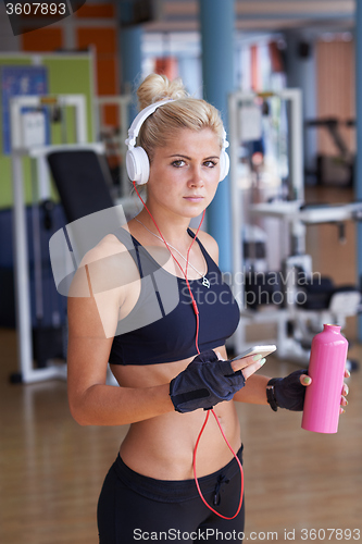Image of woman with headphones in fitness gym