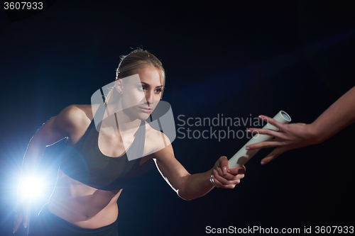 Image of athletic runners passing baton in relay race