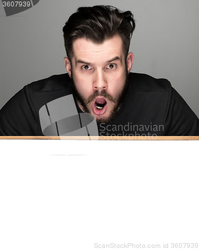 Image of The surprised man and empty blank over gray background