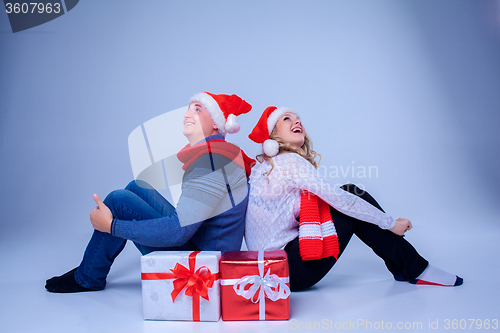 Image of Lovely christmas couple sitting with presents