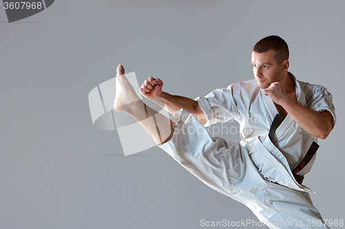 Image of Man in white kimono training karate