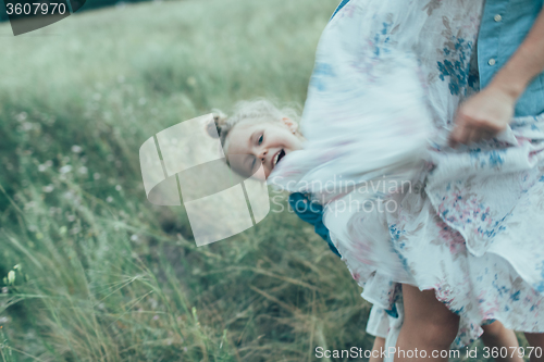 Image of The young mother and daughter on green grass background 