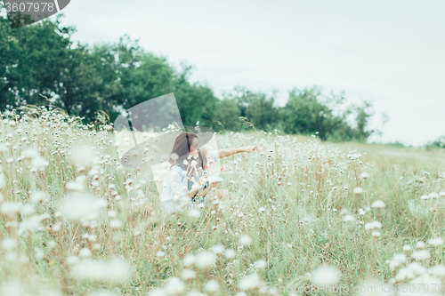 Image of The young mother and daughter on green grass background 