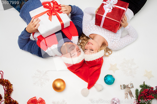 Image of Lovely christmas couple lying with presents