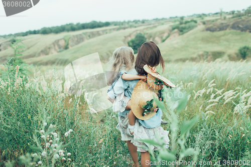 Image of The young mother and daughter on green grass background 