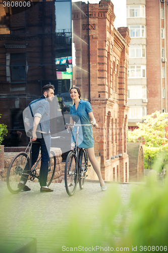 Image of Young couple sitting on a bicycle opposite the city 