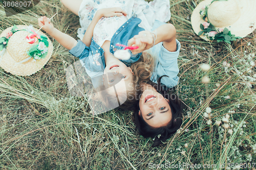 Image of The young mother and daughter on green grass background 