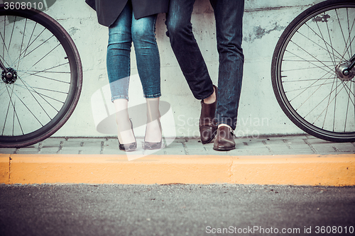 Image of Young couple sitting on a bicycle opposite the city 