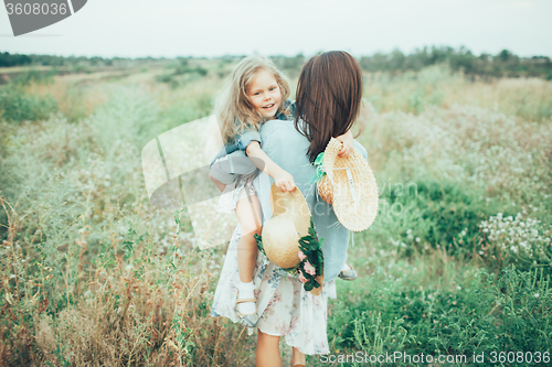 Image of The young mother and daughter on green grass background 