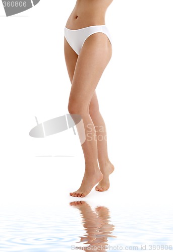 Image of long legs in bikini panties on white sand