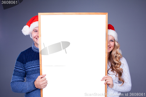 Image of Christmas couple holding white board with empty copy space 
