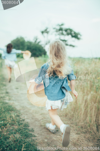 Image of The young mother and daughter on green grass background 