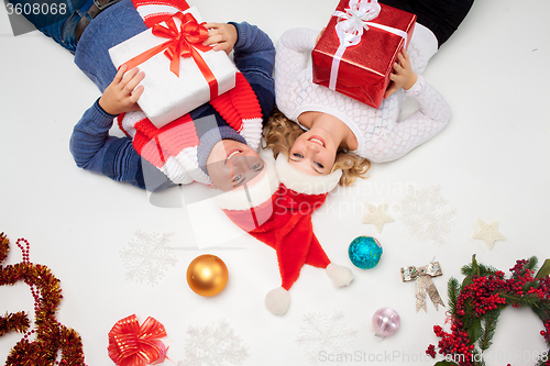 Image of Lovely christmas couple lying with presents