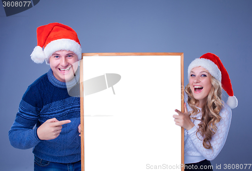 Image of Christmas couple holding white board with empty copy space 