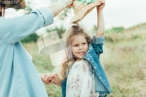 Image of The young mother and daughter on green grass background 