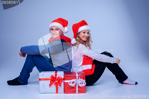 Image of Lovely christmas couple sitting with presents