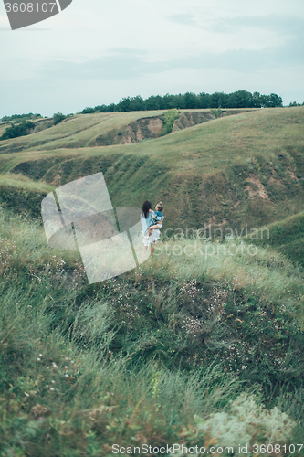 Image of The young mother and daughter on green grass background 
