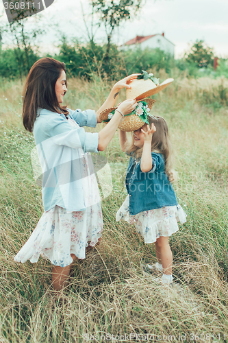 Image of The young mother and daughter on green grass background 