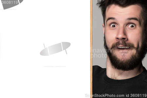 Image of The surprised man and empty blank over gray background