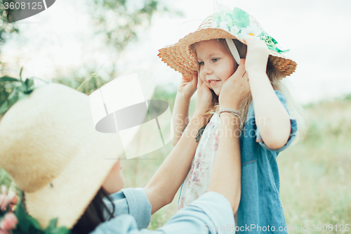 Image of The young mother and daughter on green grass background 