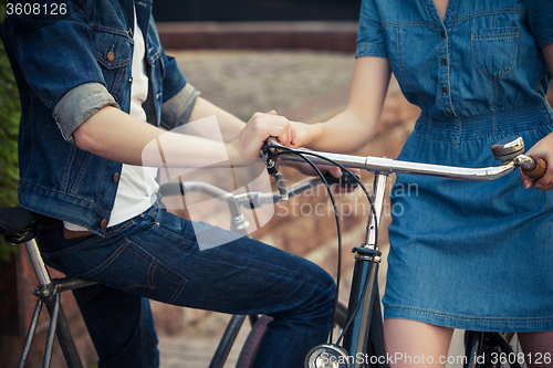 Image of Young couple sitting on a bicycle opposite the city 